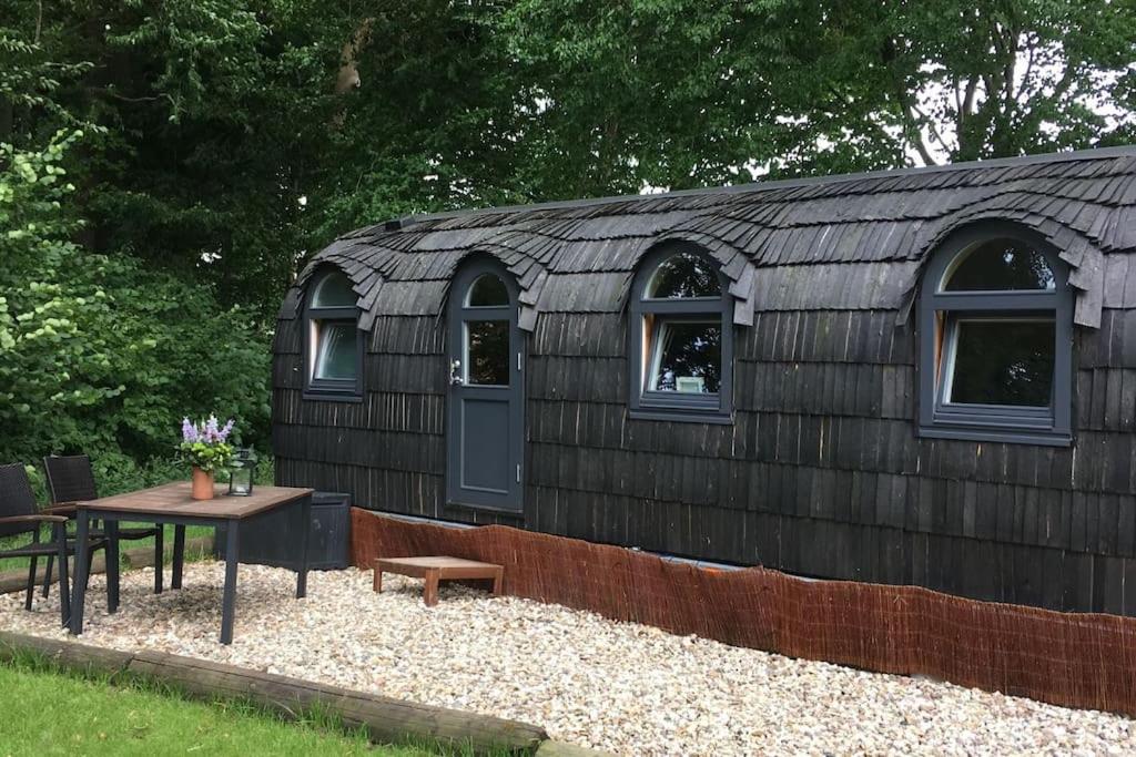 um edifício com janelas e uma mesa em frente em Tiny House Kotten Kunterbunt em Nottuln