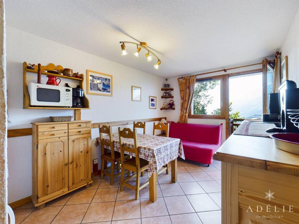 a kitchen and dining room with a table and a microwave at Appartement Montvalezan-La Rosière, 2 pièces, 4 personnes - FR-1-398-617 in Montvalezan