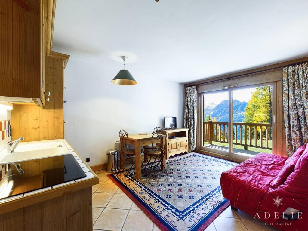 a living room with a red couch and a window at Appartement Montvalezan-La Rosière, 2 pièces, 4 personnes - FR-1-398-520 in La Rosière