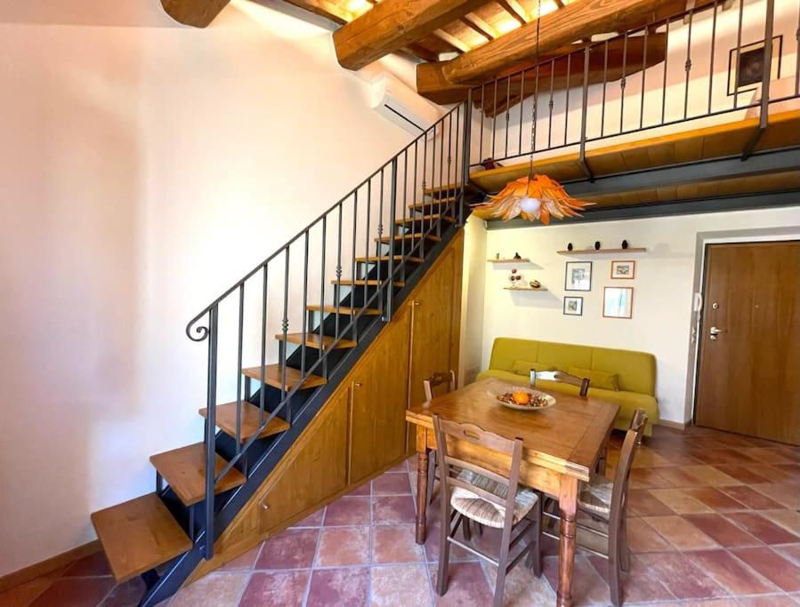 a dining room with a table and a staircase at A duecento passi- comfort nel cuore della Toscana in San Giovanni Valdarno