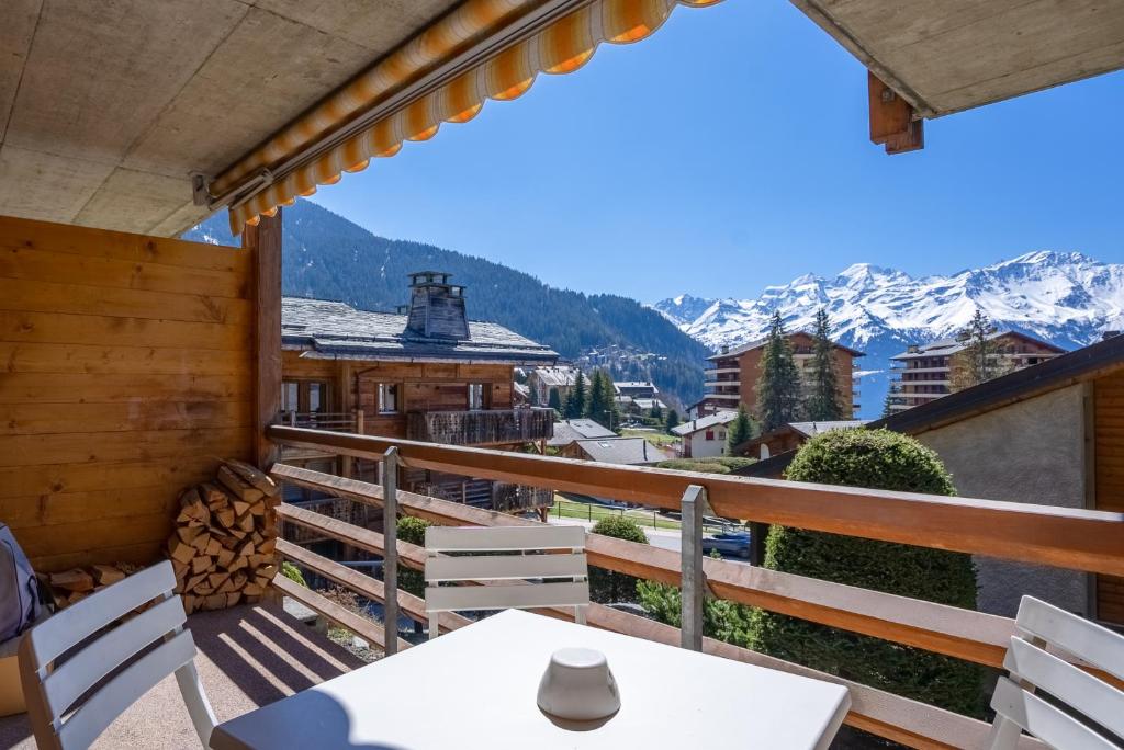 a balcony with a table and chairs and mountains at Senator 129 in Verbier