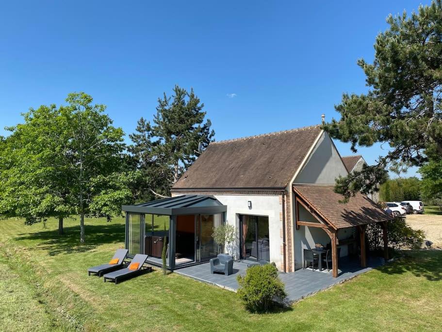 una pequeña casa con techo en un campo en Maison au cœur des étangs de Sologne avec SPA , Domaine de Sainte-Marie, en Ardon