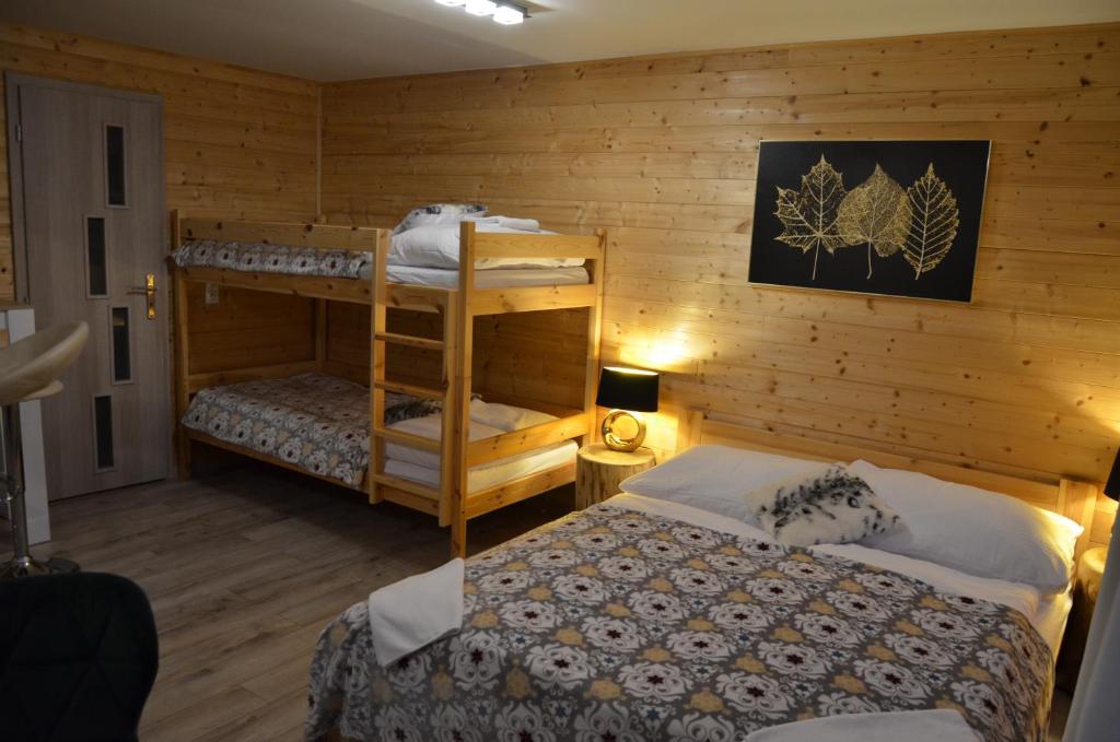 a bedroom with two beds and a bunk bed at Horská Chata Suchý vrch in Banská Bystrica