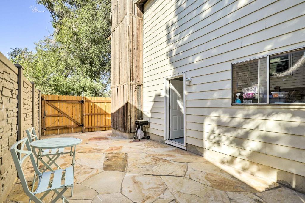 a patio with a table and a chair next to a house at West Valley City Duplex about 13 Mi to Downtown SLC! in West Valley City