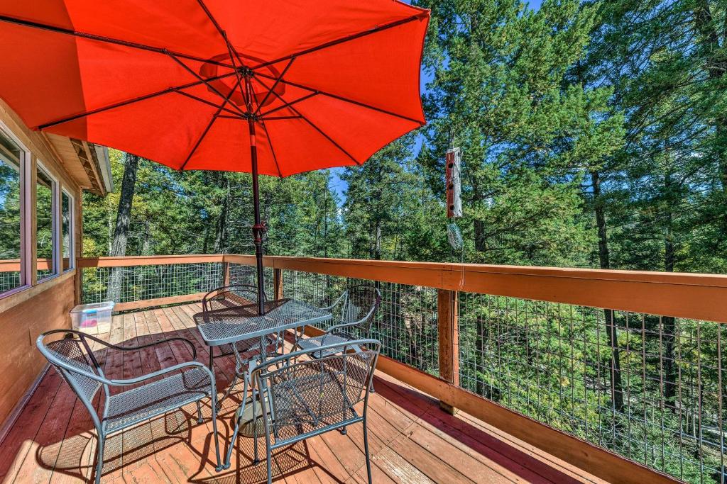 une terrasse avec une table, des chaises et un parasol dans l'établissement Cloudcroft Cabin with Deck Less Than 2 Mi to Downtown!, à Cloudcroft