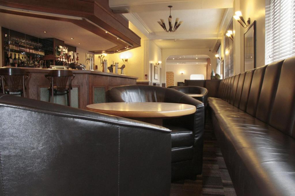a restaurant with leather seats and a table in a bar at Wortley House Hotel in Scunthorpe