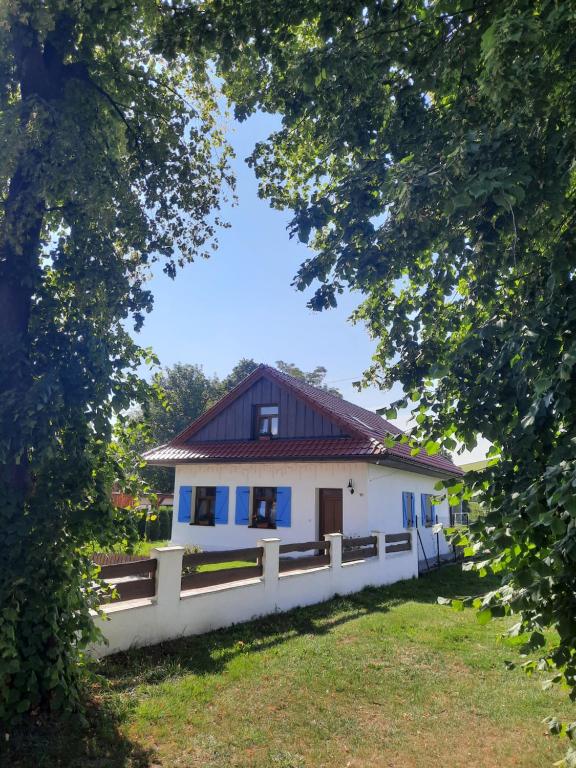 a white house with a red roof and a fence at Apartmány Máša in Liptovský Trnovec