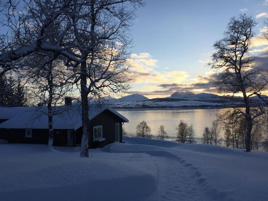 una casa en la nieve junto a un cuerpo de agua en Great house with amazing location!!Sea & mountain view!, en Kvaløya