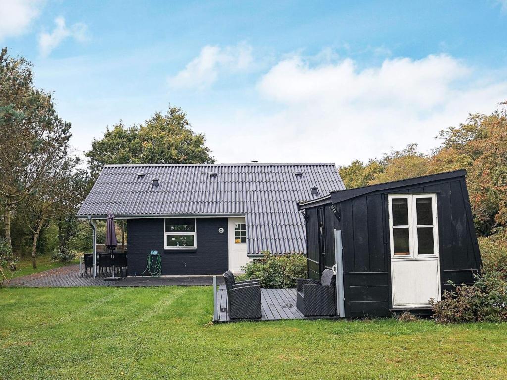 ein kleines schwarzweißes Haus in einem Hof in der Unterkunft 8 person holiday home in Skals in Skals