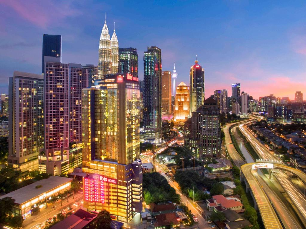 eine Skyline der Stadt in der Nacht mit vielen hohen Gebäuden in der Unterkunft ibis Kuala Lumpur City Centre in Kuala Lumpur