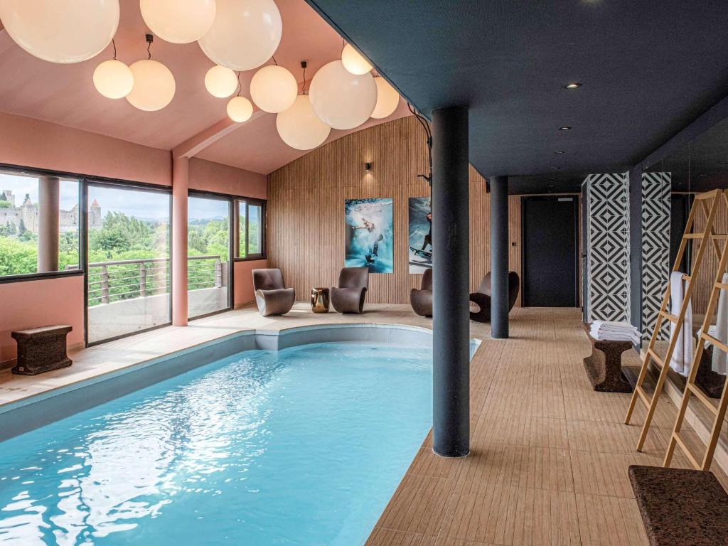 una gran piscina en una habitación con una casa en Tribe Carcassonne en Carcasona