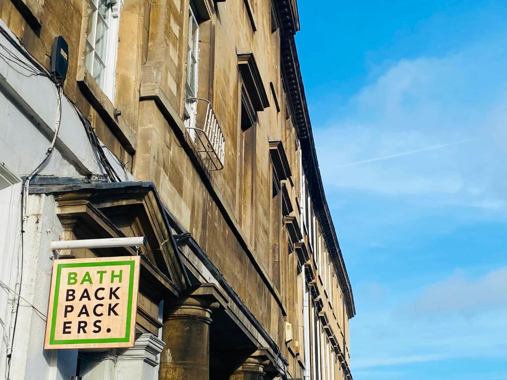 a sign on the side of a building that says faith back pack fees at Bath Backpackers in Bath