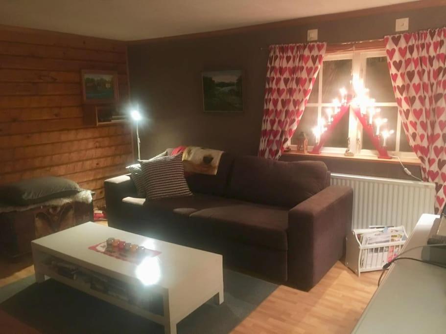 a living room with a couch and a coffee table at StugaNäraKungsberget - mysig stuga med kamin, grillkåta och vedbastu in Ockelbo