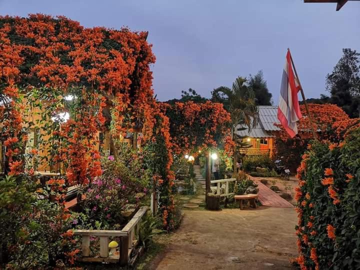 a garden filled with lots of red flowers at Lung Soi Nguen Homstay Pang Oung in Pang Ung