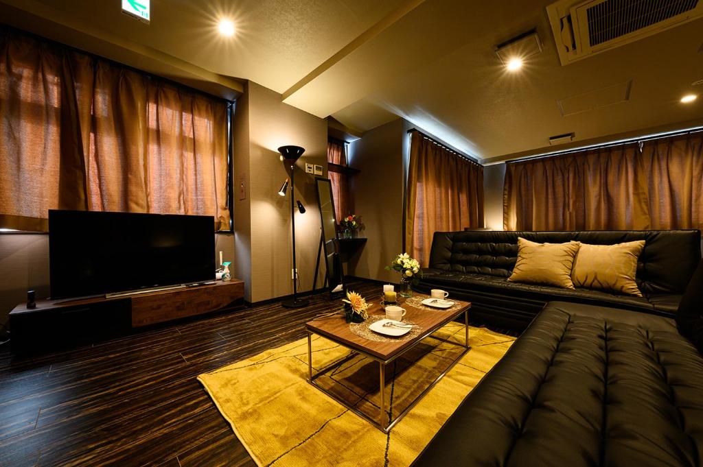 a living room with a couch and a television at MJステイズ in Kita-rokujō
