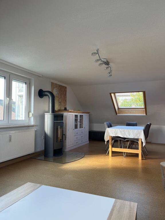 a living room with a table and a stove at Eigene Wohnung im Dreifamilienhaus EM2024 plus Ticket auf Anfrage Stadion Stuttgart in Oberstenfeld