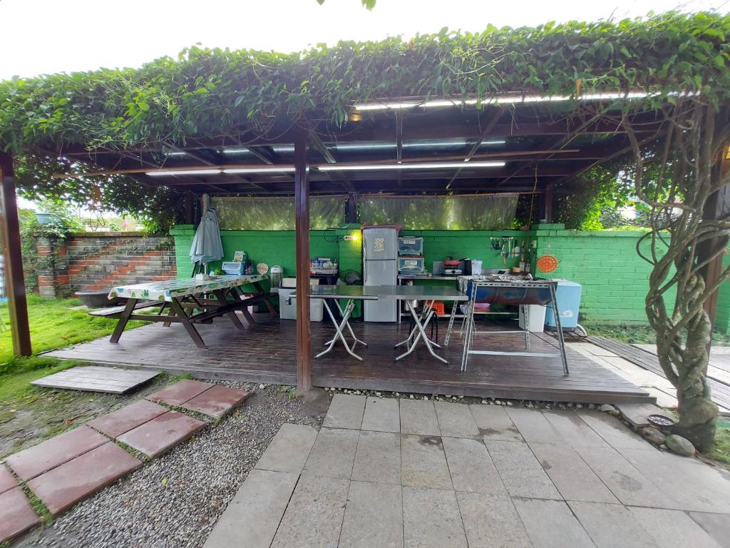 a pergola with a table and a kitchen in a garden at Gengmengyuan B&amp;B in Xikou