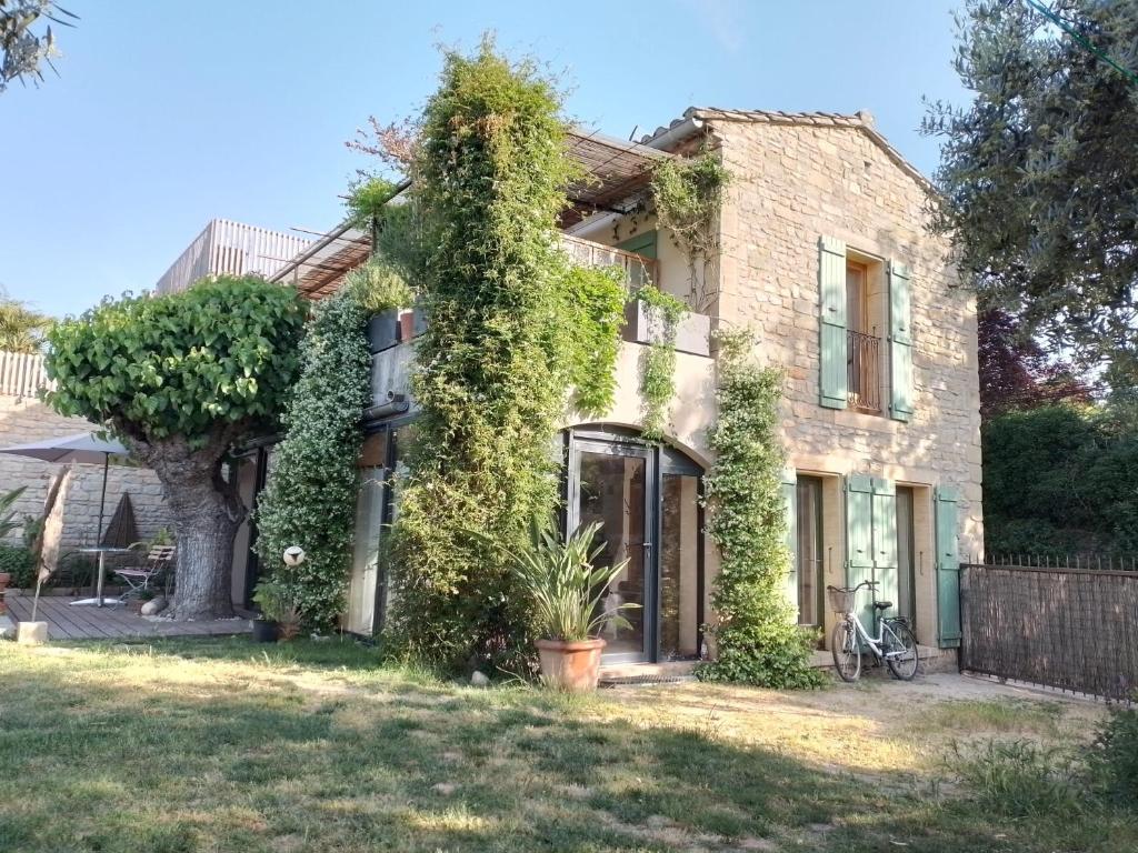 a house with ivy growing on the side of it at Charming stone villa with pool & garden in Montaren-et-Saint-Médiers