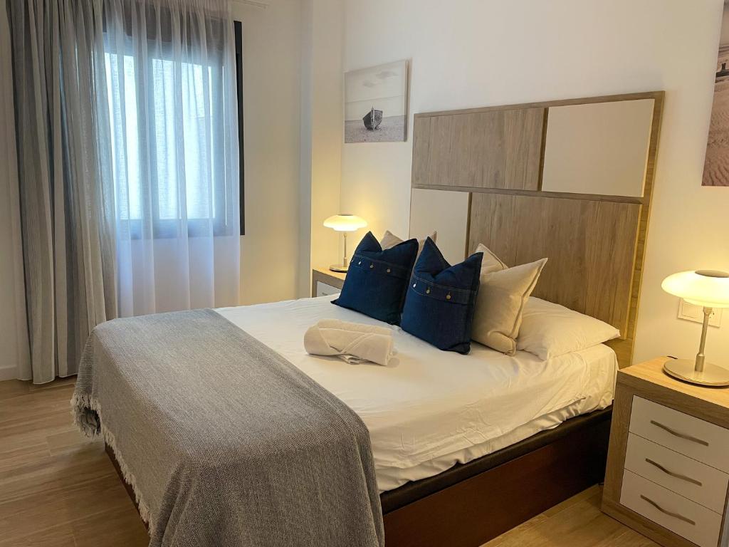 um quarto com uma cama grande e almofadas azuis em La Rosa Apartment Los Boliches Fuengirola Malaga Spain em Fuengirola