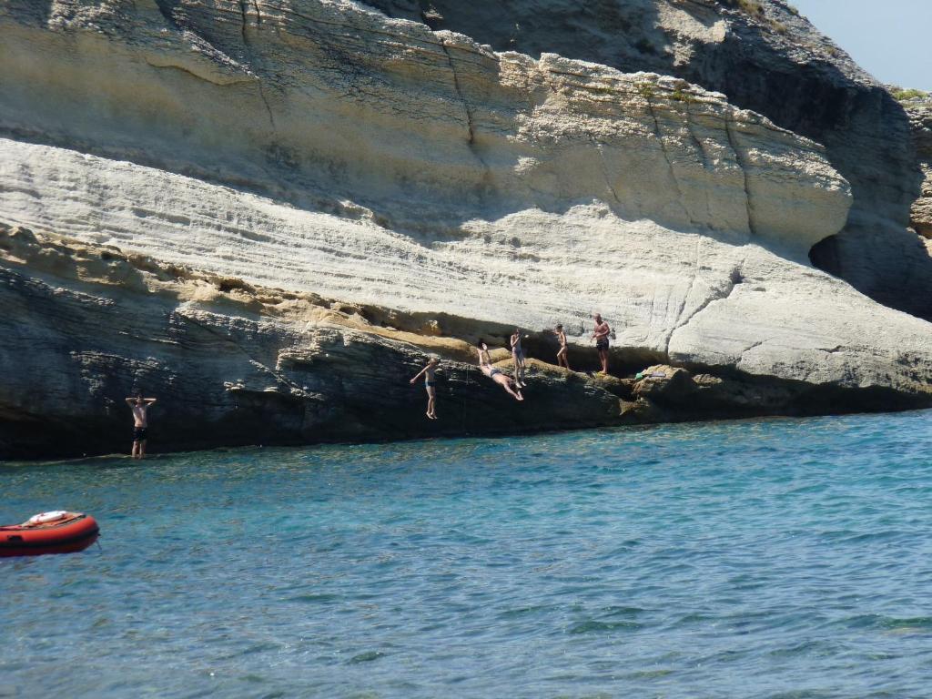 un grupo de personas escalando sobre una roca en el agua en Camping Mobile Home U sole marinu, en Patrimonio