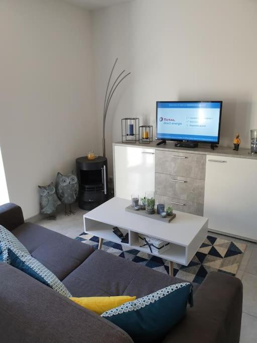 a living room with a couch and a tv at Studio entre Clohars Carnoet et Doelan in Clohars-Carnoët