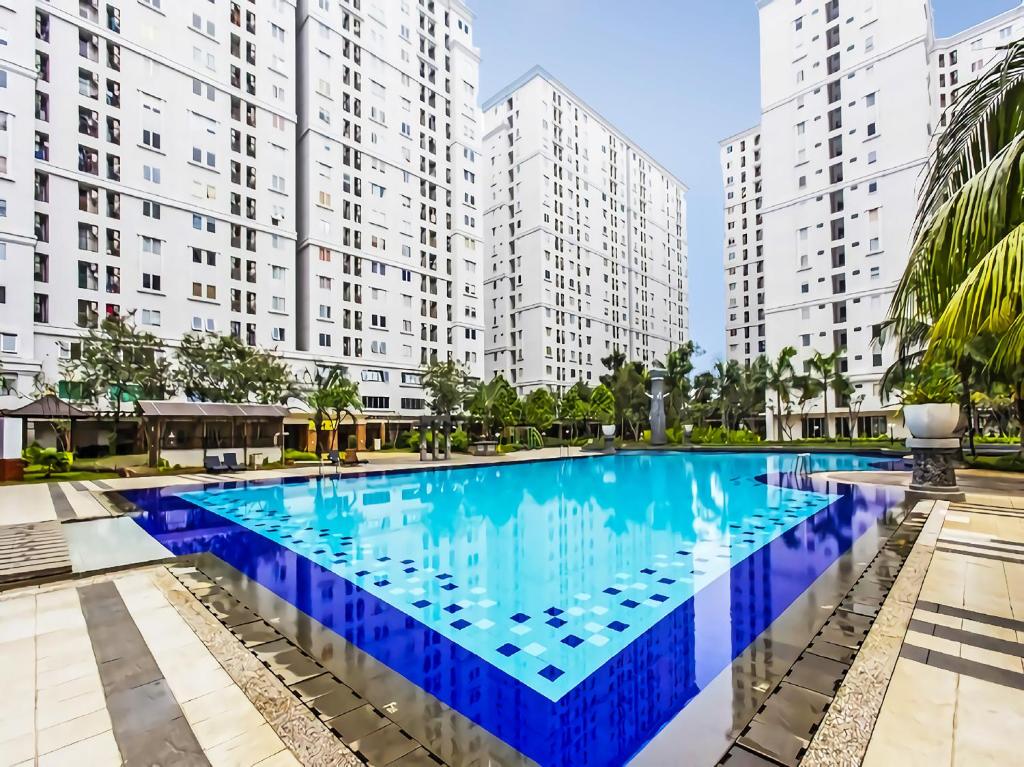 a large swimming pool in front of tall buildings at Capital O 91820 S&a Collection 2 in Jakarta