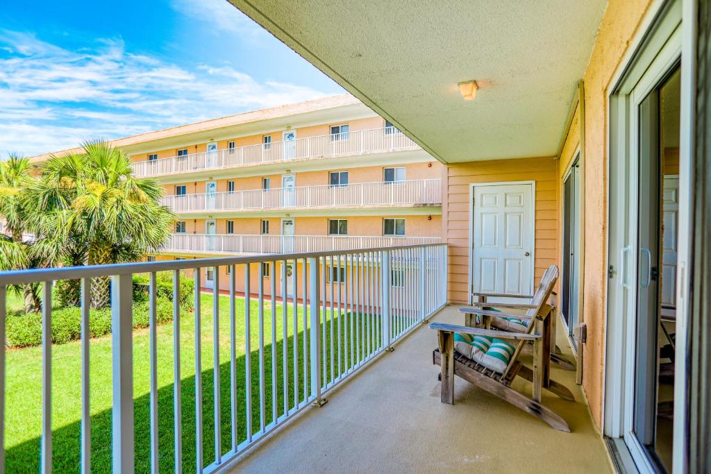 een balkon met een tafel en een bank bij Ocean view condo in beachfront resort with WiFi, central AC, 2 pools, & tennis in St. Augustine