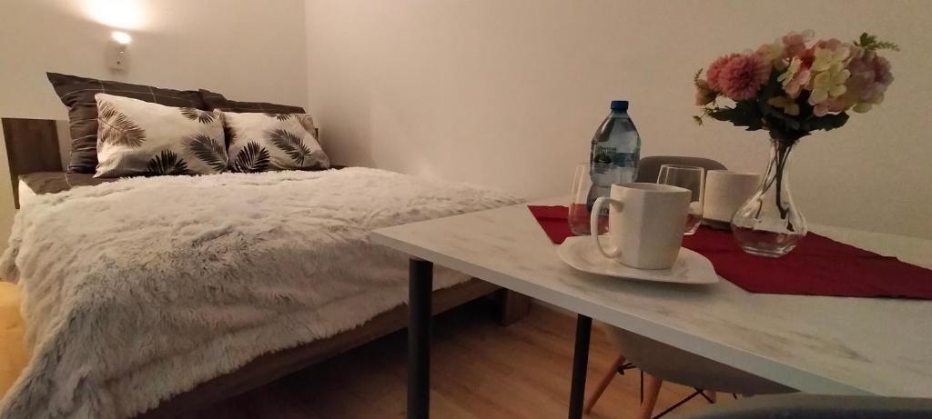 1 dormitorio con 1 cama y 1 mesa con flores en Apartament Sosnowiec - Kazimierz Górniczy en Sosnowiec