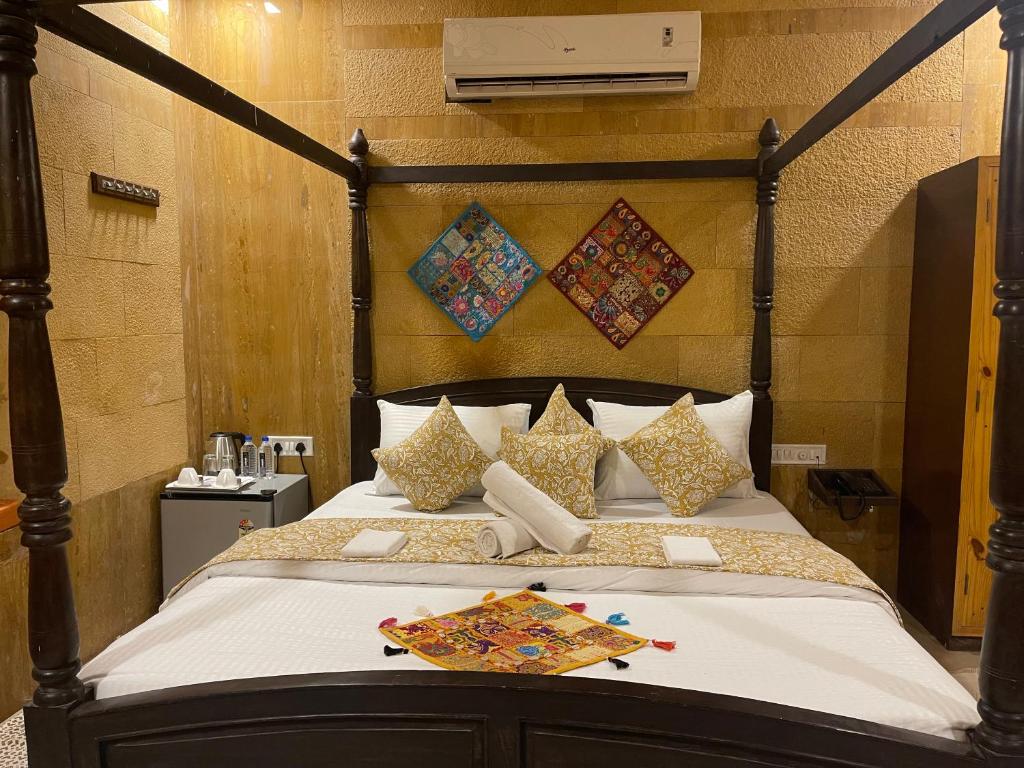 Schlafzimmer mit einem großen Bett mit einem Kopfteil aus Holz in der Unterkunft Hotel Meerana in Jaisalmer