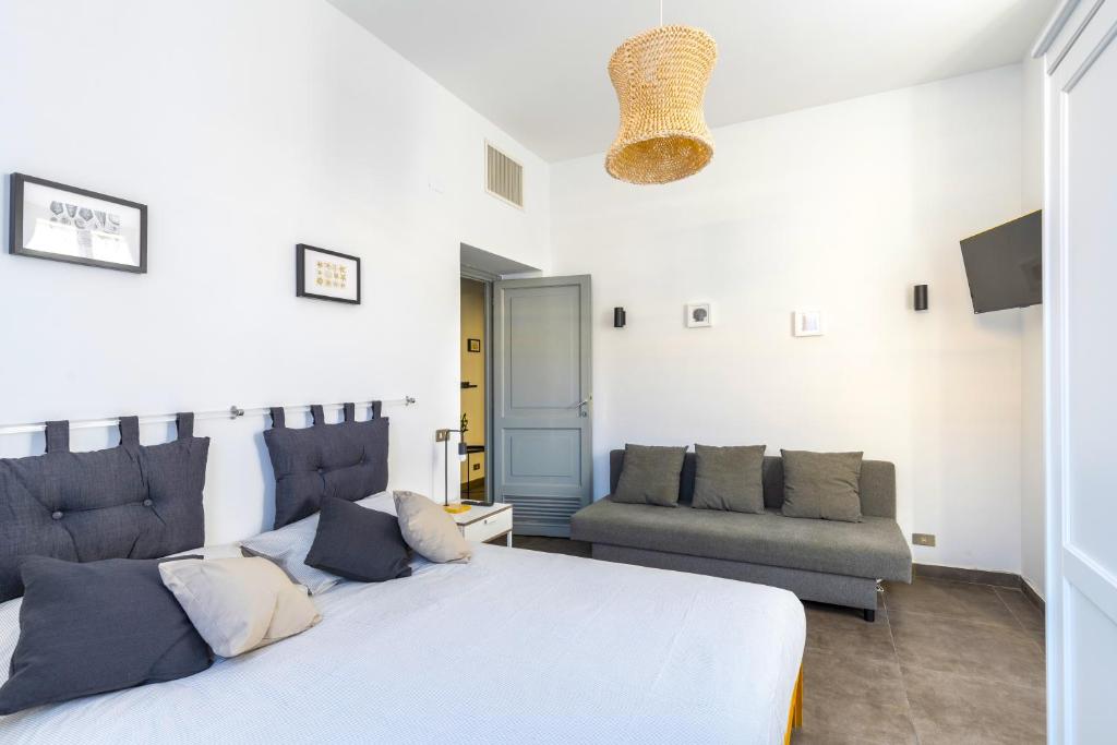 a bedroom with a large bed and a couch at Hostly - Nicole Apartment Volturno- Full Rome Center in Rome