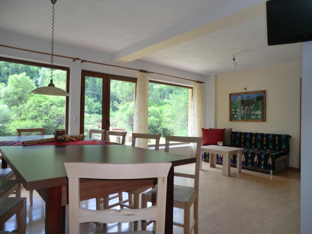 a dining room and living room with a table and chairs at Casa Silvia in Gîrda de Sus