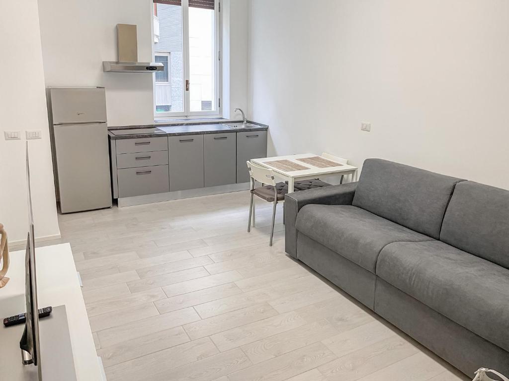 ein Wohnzimmer mit einem Sofa und einer Küche in der Unterkunft BNB Capital Milano Moscova - White in Mailand
