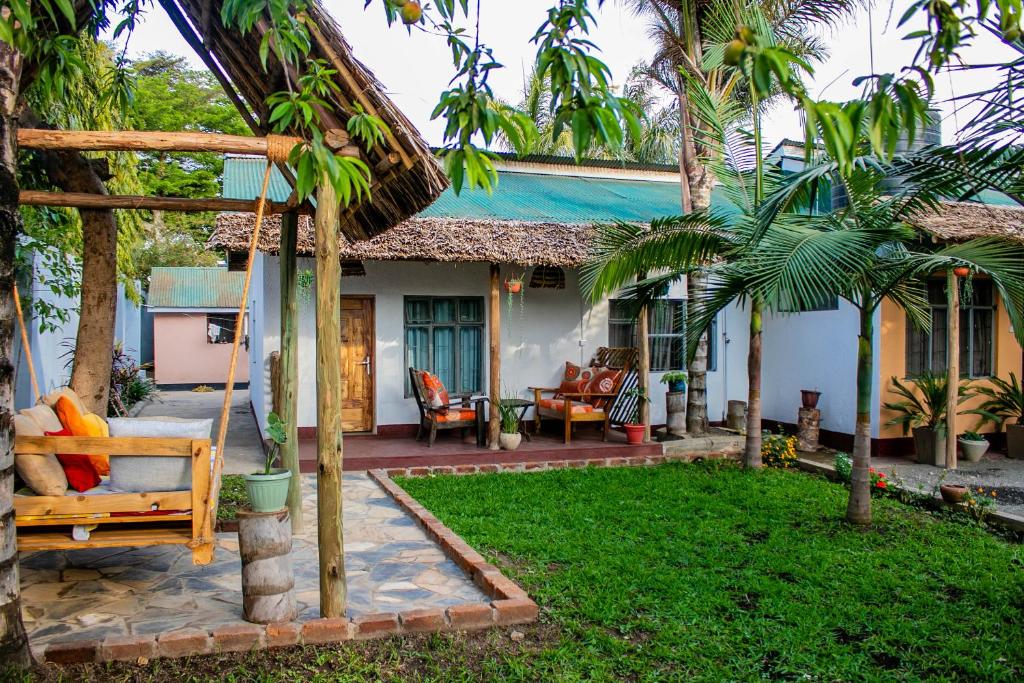 a house with a porch with a swing and a yard at Blue elephant villas in Arusha