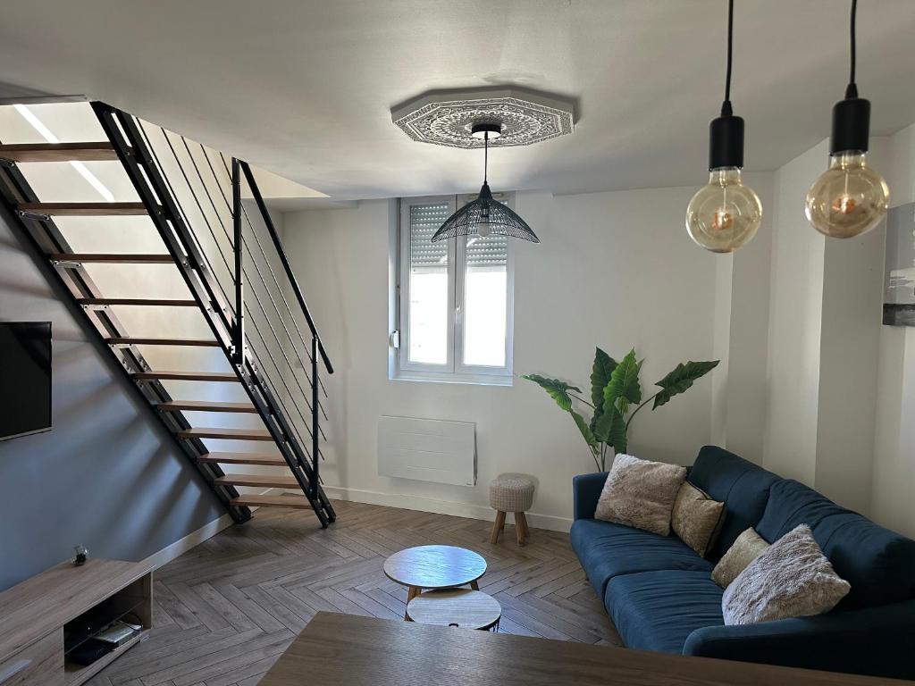 a living room with a blue couch and a staircase at Le Cocon Gambetta in Reims