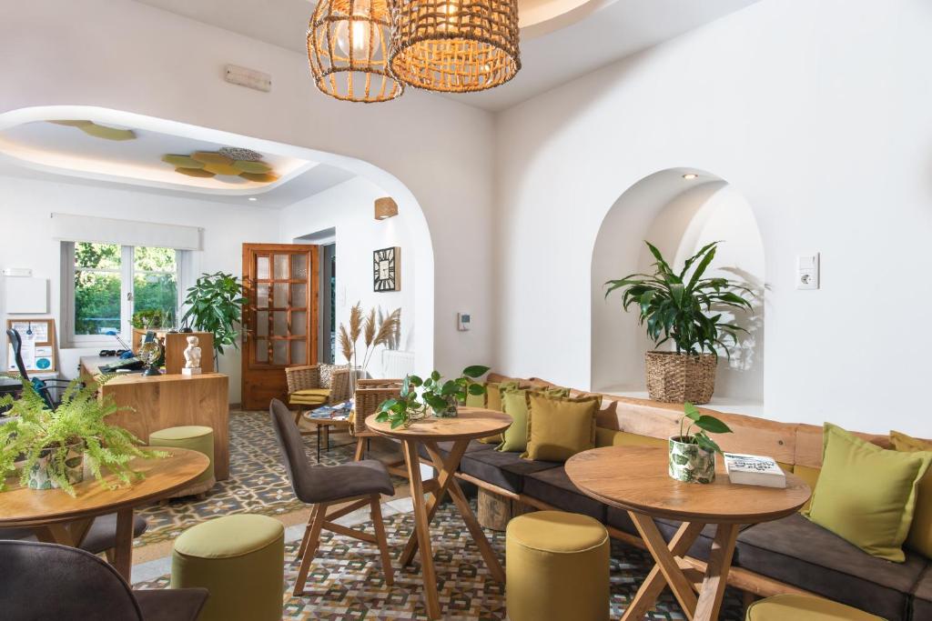 a restaurant with tables and chairs and a couch at Semiramis Guesthouse in Adamas