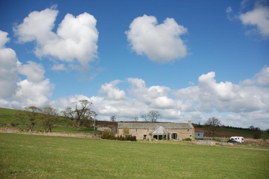 a house in a field with a green field at Crake Trees Manor in Crosby Ravensworth