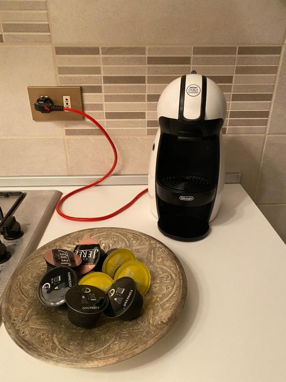 a coffee pot on a counter next to a plate of buttons at La casa di Peppe e Lucia in Poggio Bustone