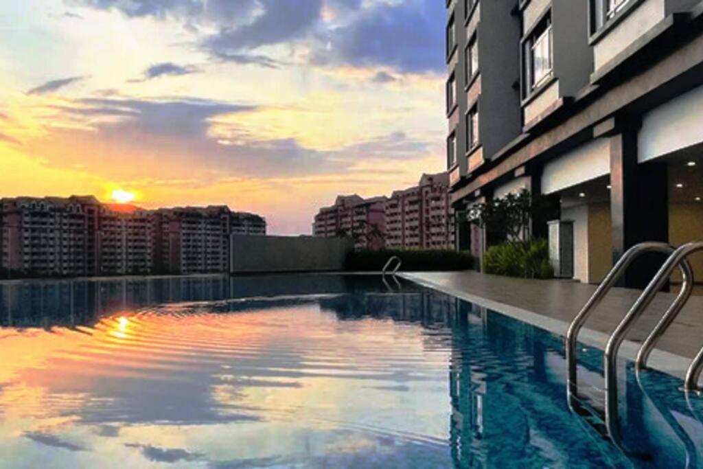 a swimming pool on the side of a building with a sunset at New Condo SYMPHONY II in Kajang , Semenyih in Semenyih