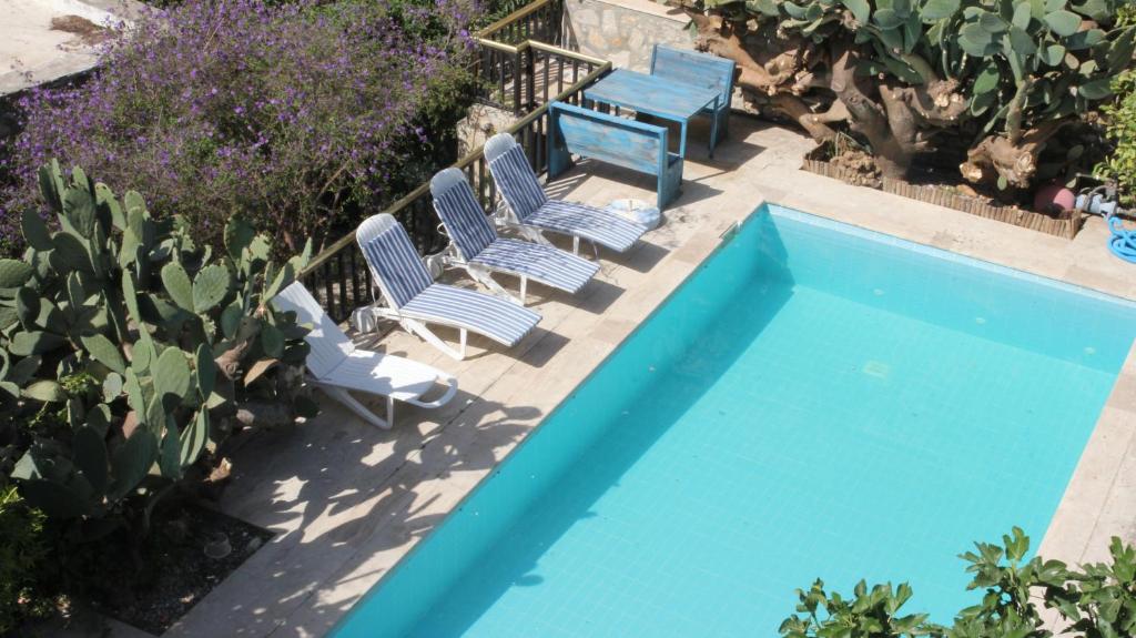 two chairs and a table next to a swimming pool at Eski Datça Pansiyon in Datca