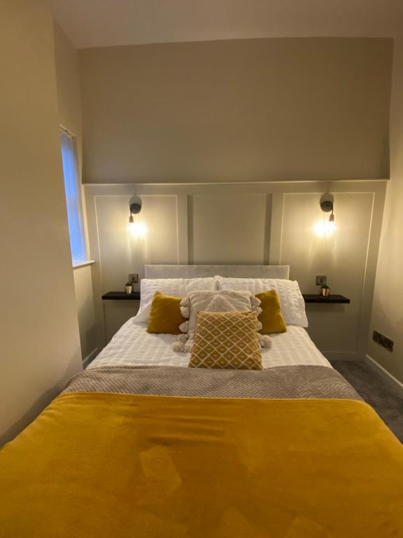 1 dormitorio con 1 cama grande con sábanas y almohadas amarillas en Cosy Loft Apartment en Ballycastle