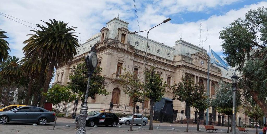a large building with cars parked in front of it at Apart Plaza in San Salvador de Jujuy