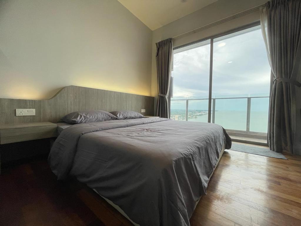 a bedroom with a large bed and a large window at Silverscape,Res -- Seaview -- Balcony -- 7 pax in Melaka
