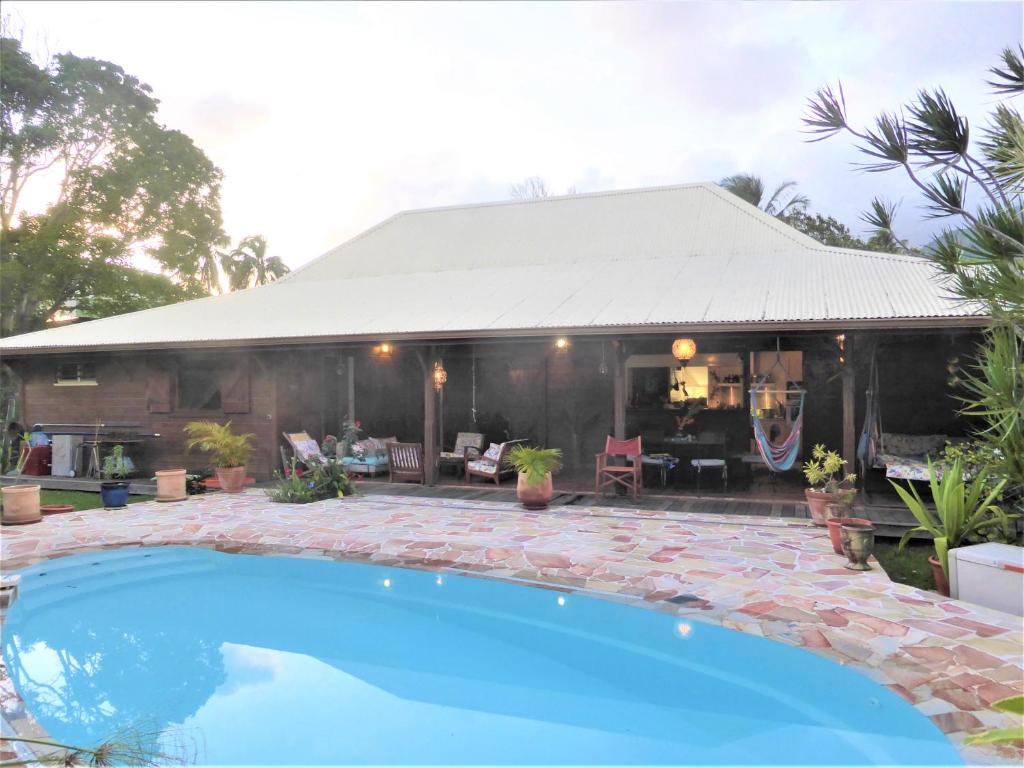 a house with a blue swimming pool in front of it at Caribbean Ashanti Lodge in Trois-Rivières