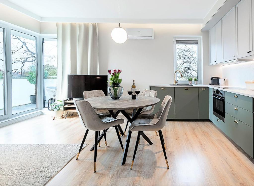 a kitchen and dining room with a table and chairs at River View Apartment z prywatnym podziemnym parkingiem in Iława
