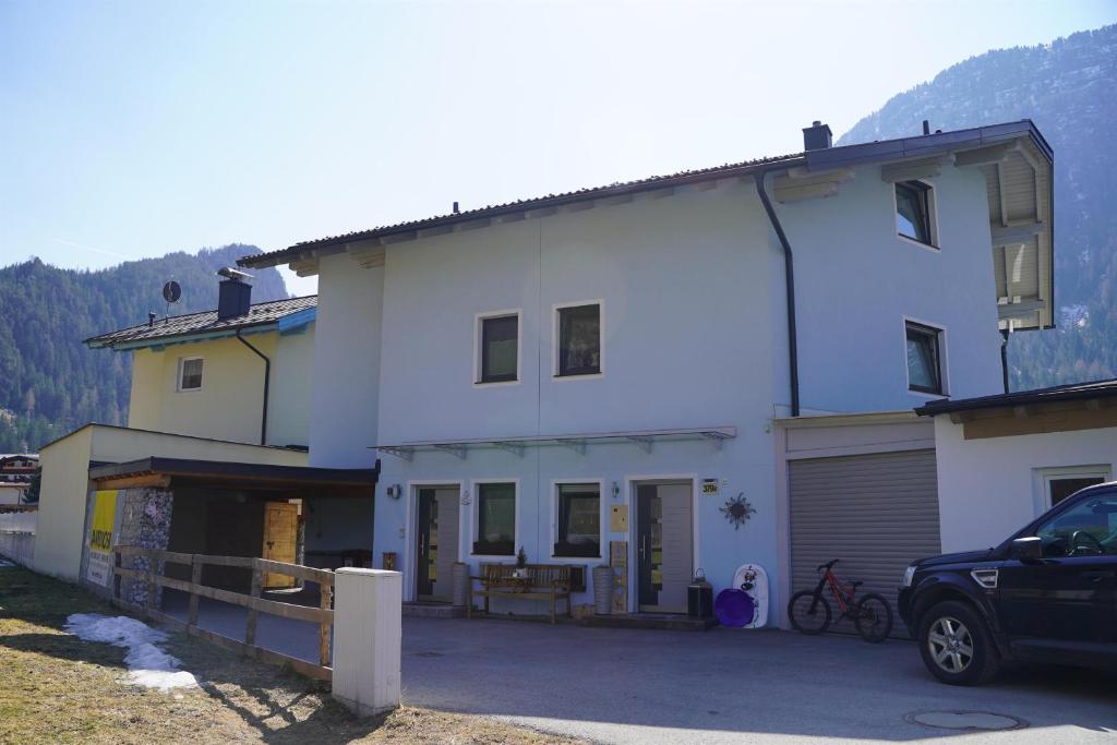 una casa blanca con un coche aparcado delante de ella en Haus Laura, en Längenfeld