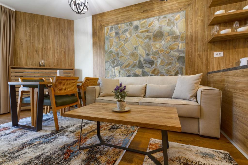 a living room with a couch and a table at Golden Pine, a private apartment in five star hotel in Zlatibor