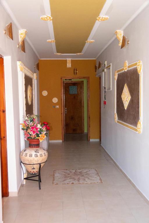 a hallway with yellow walls and a door with a vase at Villa EnElladi in Neos Pirgos