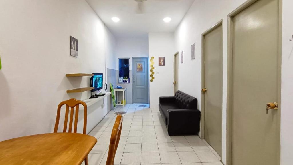 a living room with a black couch and a table at Taman Tunku Miri Budget Homestay in Miri