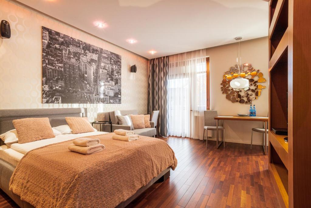 a bedroom with a bed and a living room at Broadway - Neptun Park by OneApartments in Gdańsk