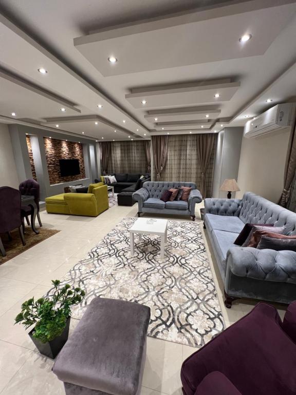 a large living room with couches and a rug at Cozy and Modern Apartment for Rent in Mohandessin in Cairo